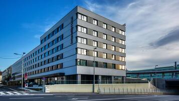 A modern hotel with multiple floors, large windows, and a flat roof.