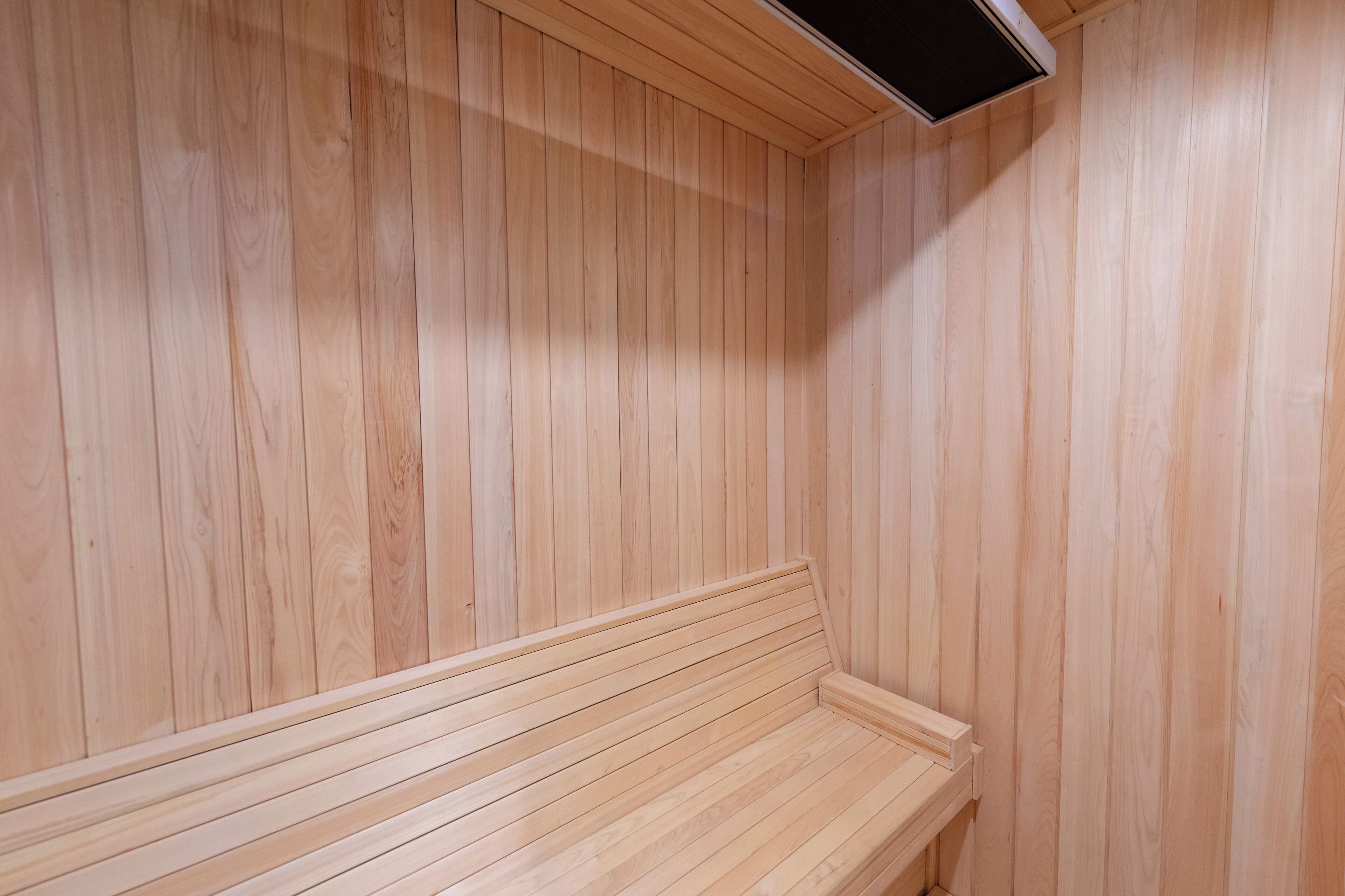 Una sauna de madera con un banco y un sistema de ventilación.