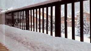 A snow-covered balcony with a wooden floor and a metal railing. - Hôtel les Lorès (Val-d'Isere)