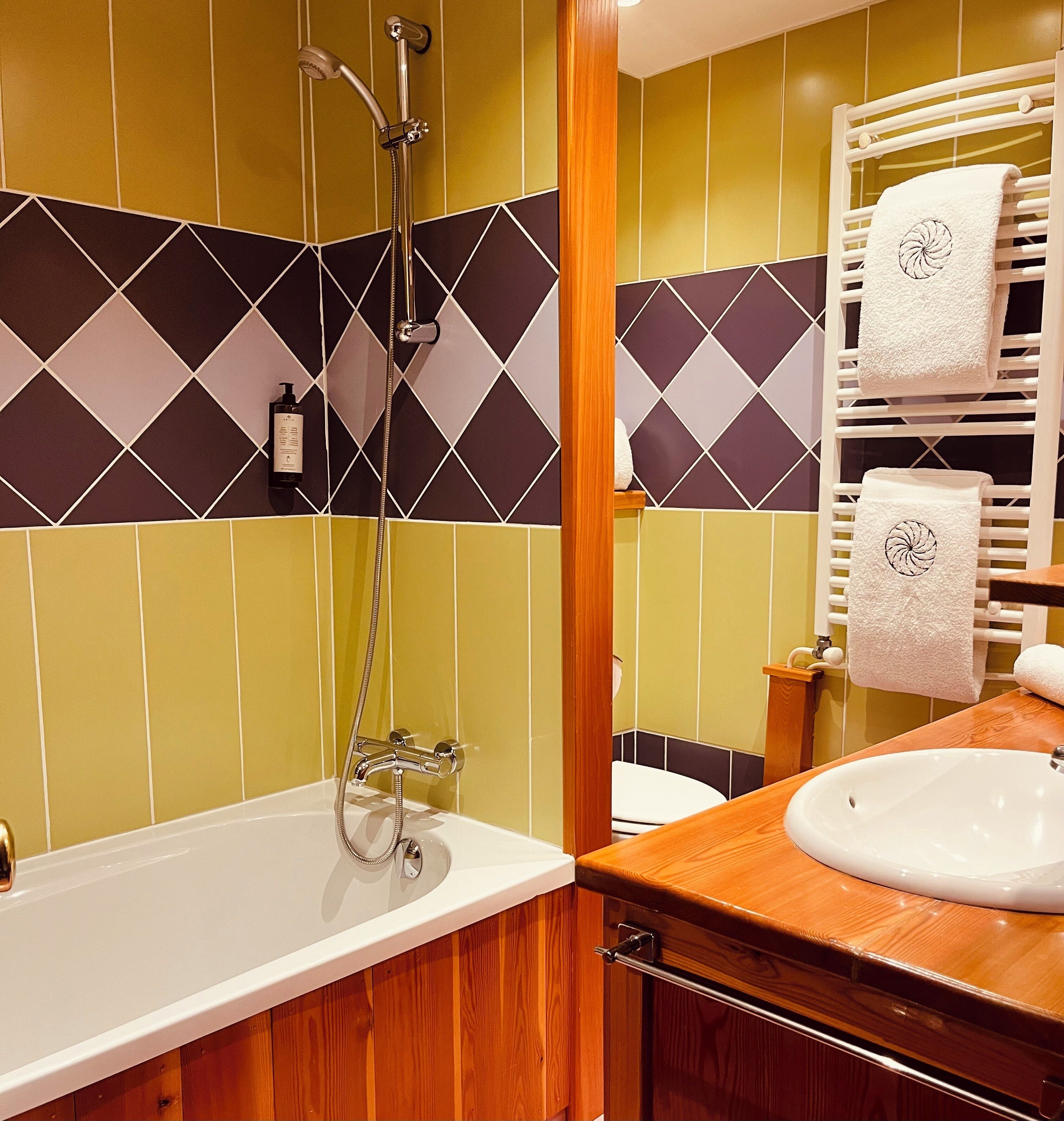 Un baño con bañera, ducha y lavamanos.