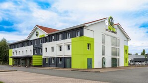 Un hôtel moderne à la structure à deux étages, doté d’une entrée couverte et d’un espace de stationnement.