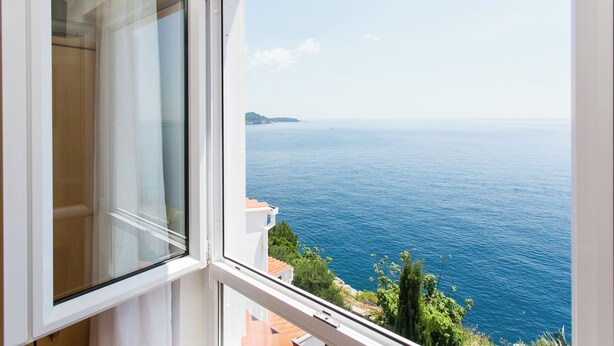 Ein Fenster mit Blick auf das Meer und ein entferntes Land.