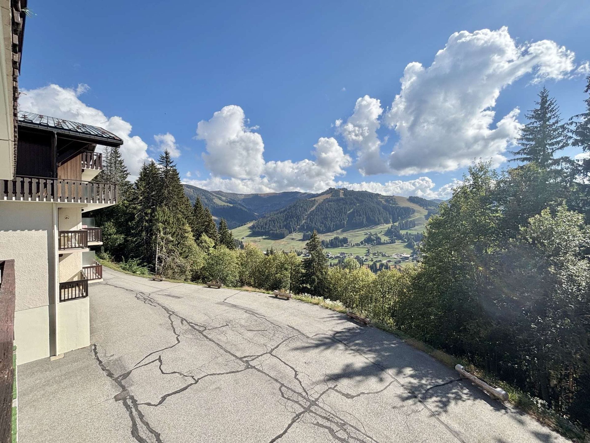 Un edificio con balcón que da a un paisaje montañoso.