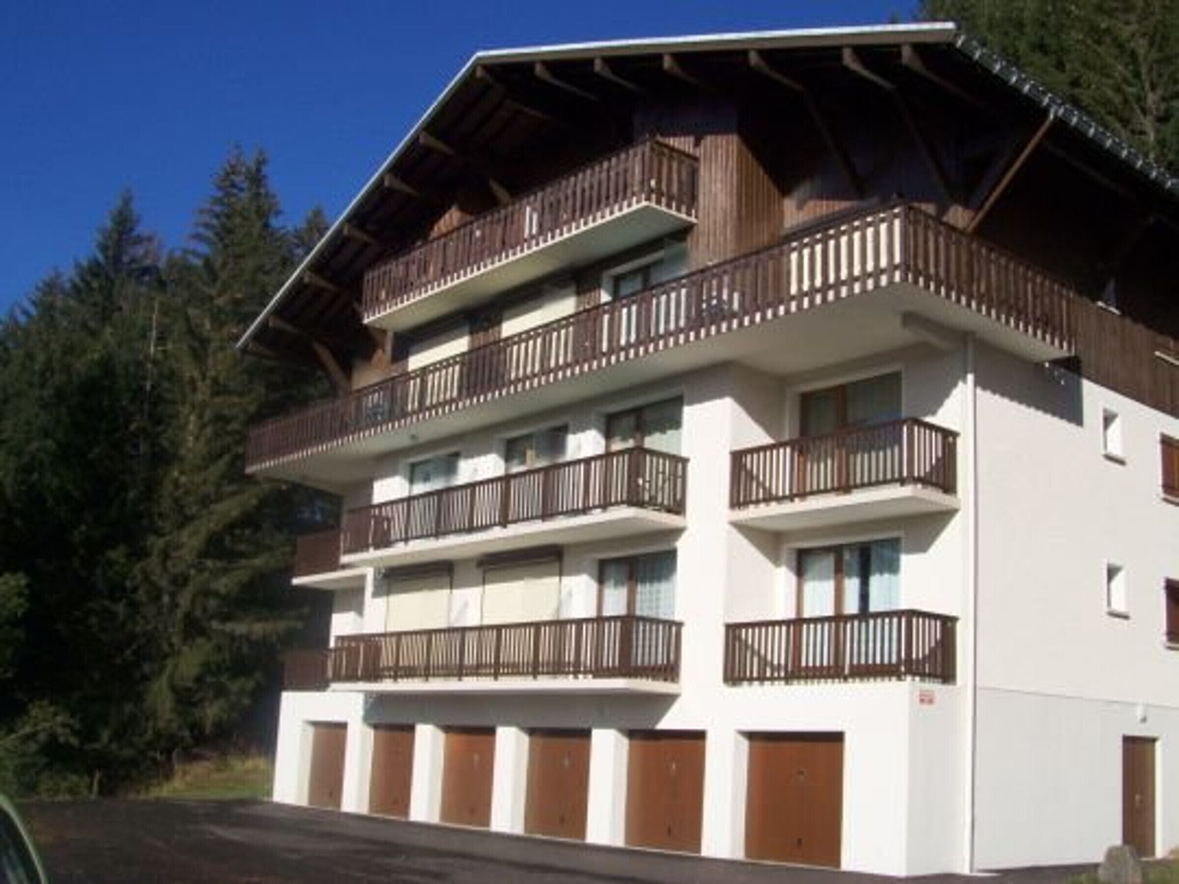 A multi-story building with balconies, a flat roof, and a white facade.