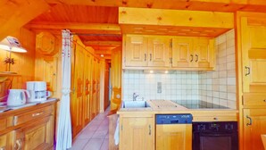 A wooden kitchen with a dishwasher, stove, and cabinets. - 2-room apartment Les Saisies, top of resort, 6 people, balcony. (Les Saisies)