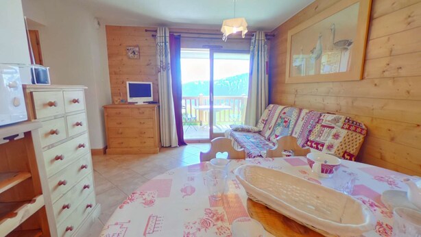 Une chambre confortable avec un lit, une commode, une télévision et un balcon offrant une belle vue.
