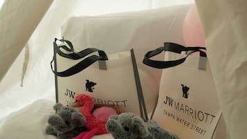 Una estructura tipo tienda de campaña con dos bolsas JW Marriott y peluches en su interior.
