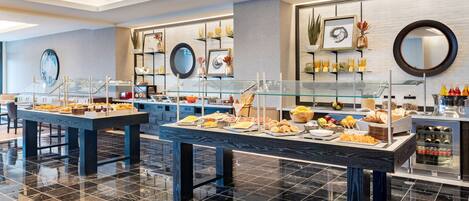 A buffet area with various food items and a modern interior design.