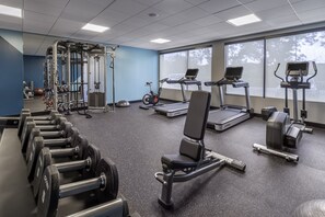 A gym with exercise equipment, treadmills, and weights.