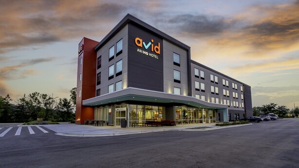 A modern hotel building with a prominent 'Avid' sign, large windows, and a covered entrance area. - avid hotel Milwaukee West Waukesha by IHG (Pewaukee)