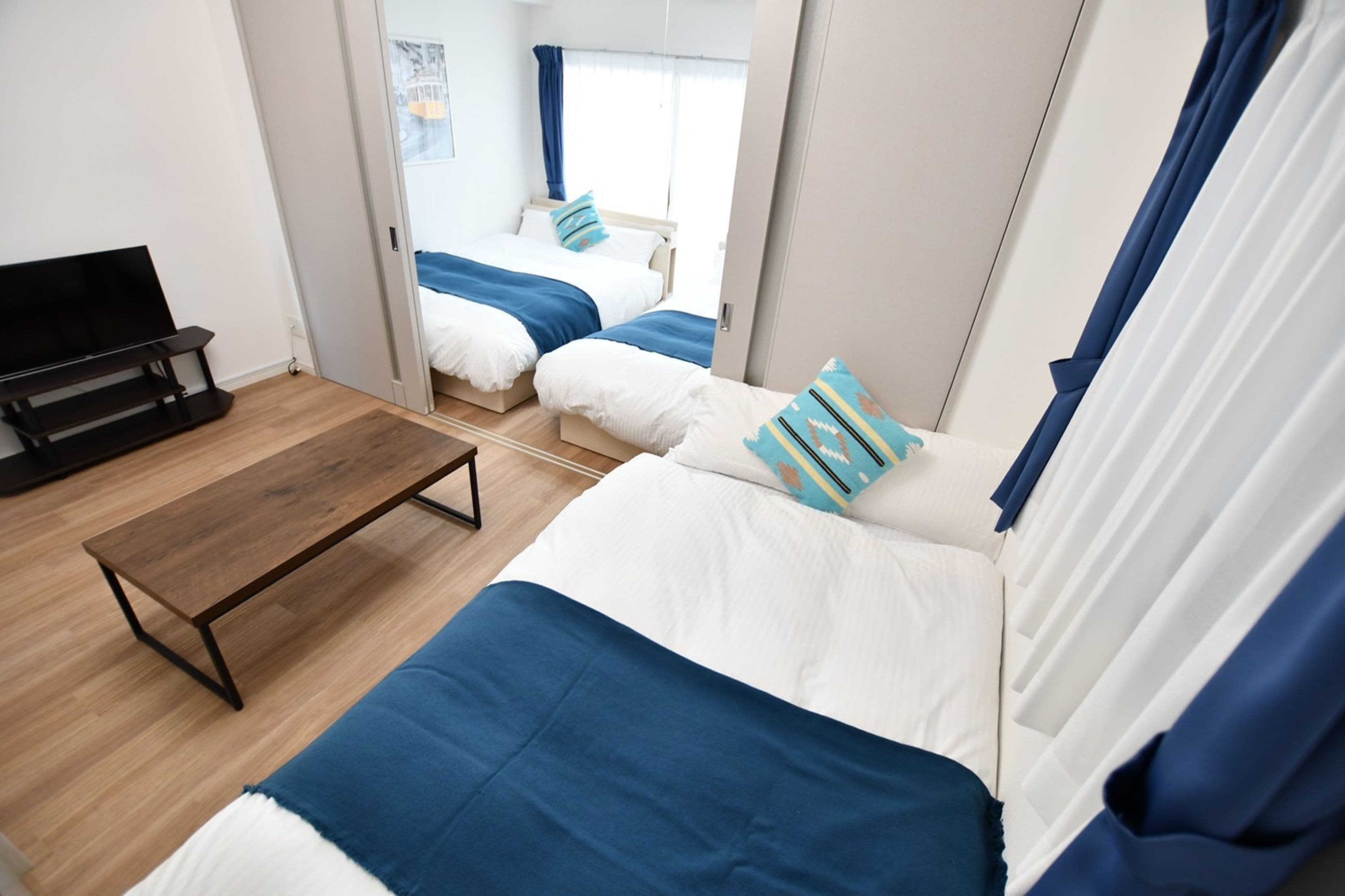 A modern hotel room with a bed, a bench, and a TV.