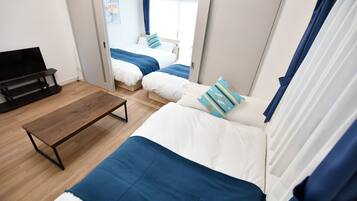A modern hotel room with a bed, a bench, and a TV.
