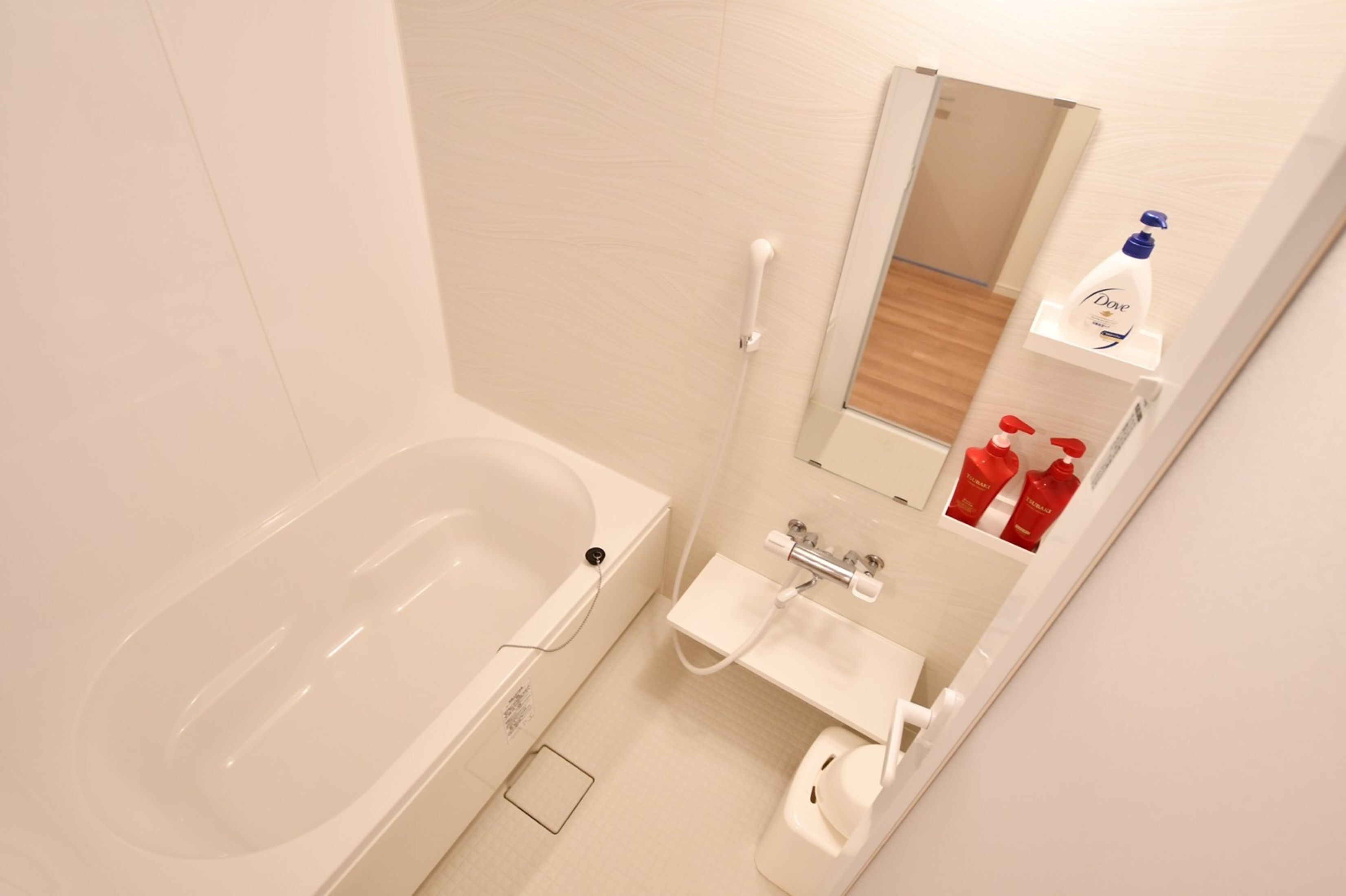 A bathroom with a bathtub, a sink, and a mirror.