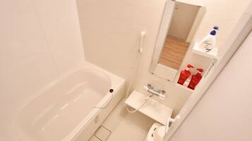 A bathroom with a bathtub, a sink, and a mirror.