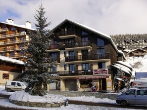 A multi-story hotel with balconies, a sign for 'la Trace', and snow-covered surroundings. - Mezzanine studio Les Saisies, 4 pers, central (Les Saisies)