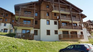 Un immeuble en bois à plusieurs étages, doté de balcons, qui ressemble probablement à un hôtel ou à un complexe touristique.