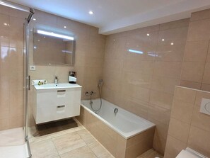 A modern bathroom with a glass shower enclosure, a white vanity with a mirror, and a separate bathtub. - Modern apartment for 8 with WIFI and parking, Les Gets (Les Gets)