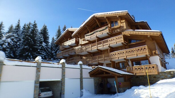 A multi-story wooden chalet with balconies, a stone facade, and a snow-covered roof. - 5-room apartment for 8 ppl in Les Saisies (Les Saisies)