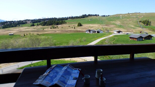 A view from a wooden deck overlooking a rural landscape with houses, a dirt path, and a clear sky. - Studio cabin Les Saisies 6 people, near center (Les Saisies)