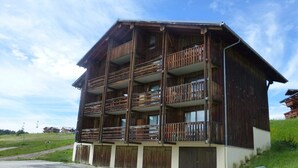 A multi-story wooden building with balconies, a flat roof, and a simple facade. - Studio cabin Les Saisies 6 people, near center (Les Saisies)