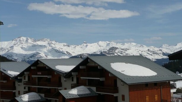 A row of wooden cabins with snow on the roofs, set against a backdrop of snow-covered mountains. - Studio cabin 4 pers, balcony, in Les Saisies (Les Saisies)