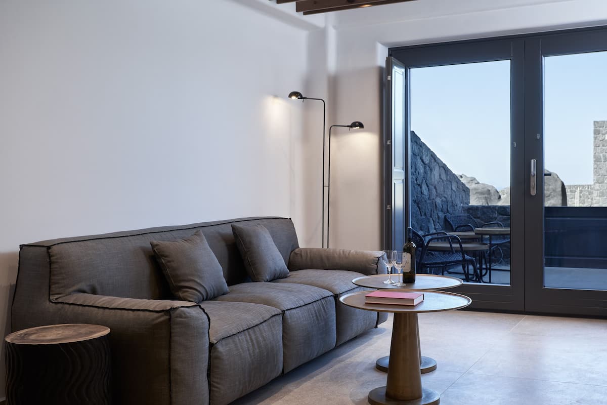 A modern living room with a grey sofa, a round coffee table, and a floor lamp.