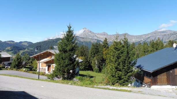 A mountain lodge with a wooden exterior, surrounded by evergreen trees and a clear blue sky. - Duplex for 6 with Garage, Near Slopes in Crest-Voland (Crest-Voland)