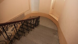 A curved staircase with ornate black metal railings and a radiator on the wall. - Duplex apartment in the historical center of Odessa (Odessa)