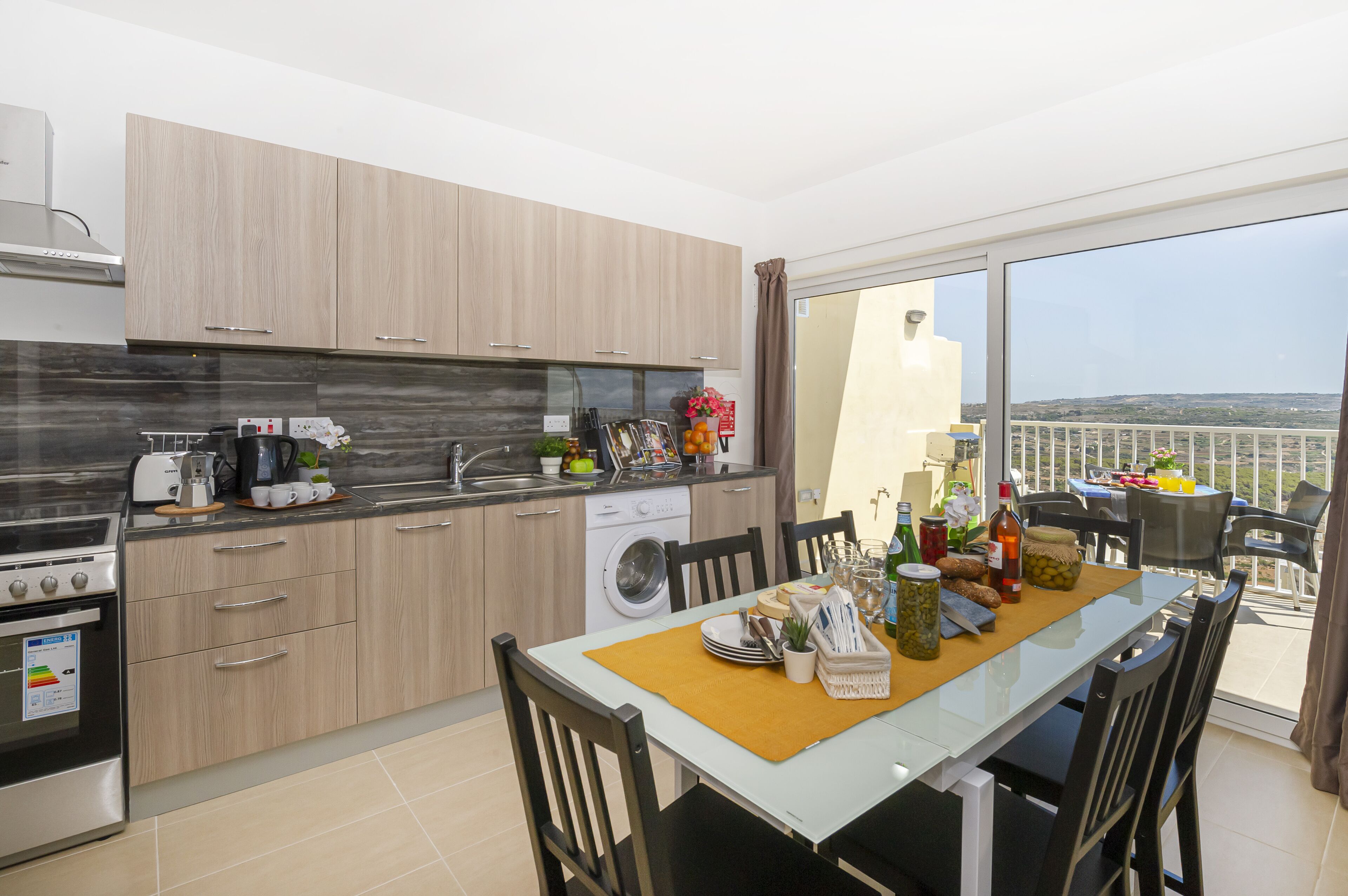 Una cocina moderna con comedor, lavadora y vistas al paisaje.