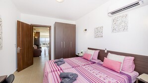 Habitación de hotel con dos camas, un armario y vista a la ciudad.