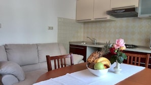 A kitchen with white cabinets, a white countertop, and a dining table with a white placemat.
