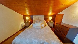 A bedroom with a large bed, two bedside tables with lamps, a dresser, and a wooden ceiling. - Charming 3-Room Apartment with Mezzanine, 1km from Ski Lifts - Megève (Megève)