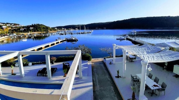 Un hotel frente al lago con terraza al aire libre y vistas.