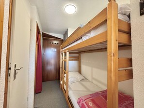A bunk bed room with a door and a red curtain. - Functional studio cabin for 6 at the foot of the slopes - Parking included (Notre-Dame-de-Bellecombe)