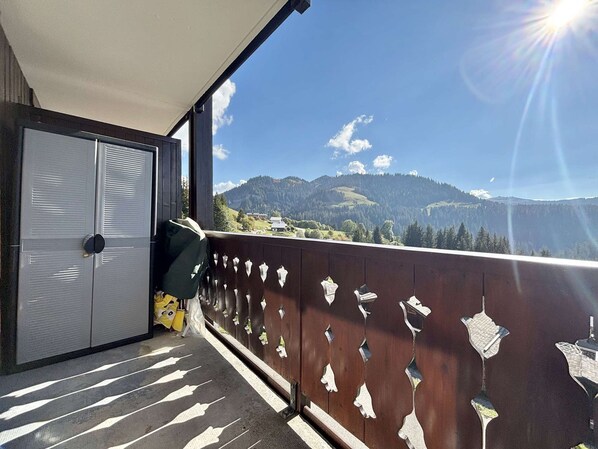 A balcony with a view of mountains, a door, and a railing with cut-out shapes. - Functional studio cabin for 6 at the foot of the slopes - Parking included (Notre-Dame-de-Bellecombe)