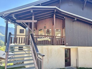 A wooden building with a balcony and a staircase leading to a door. - Functional studio cabin for 6 at the foot of the slopes - Parking included (Notre-Dame-de-Bellecombe)