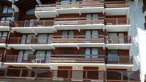 A multi-story hotel with balconies, wooden railings, and large windows. - Cozy studio Les Saisies 4 people (Les Saisies)