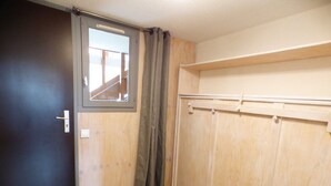 A room with a dark door, a window with a view, a wooden wardrobe, and a curtain. - Cozy studio Les Saisies 4 people (Les Saisies)