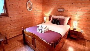 A wooden-paneled bedroom with a bed, bedside lamps, a mirror, and a window. - Bright 2BR Apartment with Terrace and Parking, Sleeps 4, Les Gets (Les Gets)
