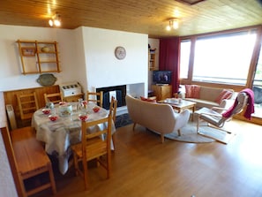 Un salón acogedor con chimenea, muebles de madera y televisor.