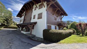 Un chalet traditionnel doté d’un toit à pente, de poutres en bois et d’un balcon.