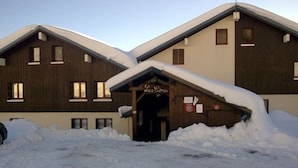 A building with a wooden facade and a sign that reads "Les Cimes." Snow covers the ground and roof. - 3-room Apartment, 2 Bedrooms, 8 ppl, Les Saisies (Les Saisies)