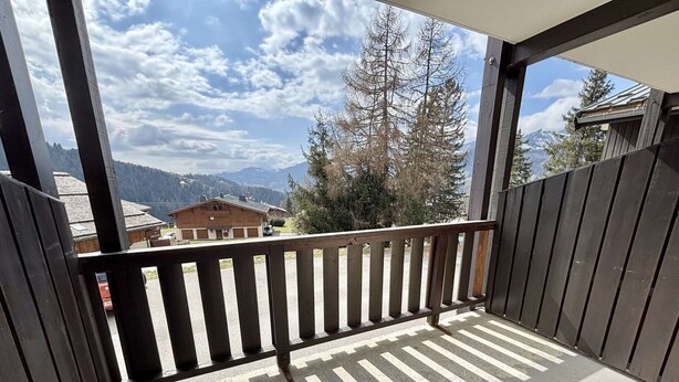 A balcony with a view of mountains and a wooden building. - Cozy Studio in Notre-Dame-de-Bellecombe - Ski-in/Ski-out, Sleeps 4, Parking & Balcony (Notre-Dame-de-Bellecombe)