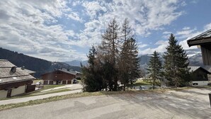 A residential area with houses, a paved driveway, and a mountain backdrop. - Cozy Studio in Notre-Dame-de-Bellecombe - Ski-in/Ski-out, Sleeps 4, Parking & Balcony (Notre-Dame-de-Bellecombe)