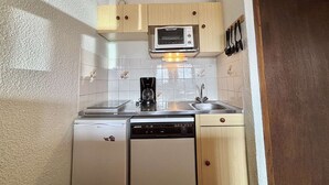A compact kitchen with a microwave, coffee maker, and dishwasher. - Cozy Studio in Notre-Dame-de-Bellecombe - Ski-in/Ski-out, Sleeps 4, Parking & Balcony (Notre-Dame-de-Bellecombe)