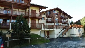 A multi-story building with wooden balconies and a staircase leading to the upper floors.