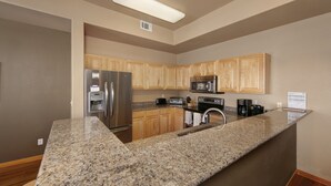 A kitchen with granite countertops, wooden cabinets, stainless steel appliances, and a built-in microwave. - Private Lakefront Luxury in the heart of Ski Country, Mountain Views (Silverthorne)