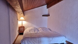 A small, narrow room with a single bed, a nightstand with a lamp, and textured walls. - Studio/Cabin with Mezzanine - Near Slopes, 5 People (Notre-Dame-de-Bellecombe)