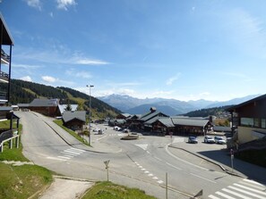 Une route menant à un bâtiment avec une montagne en arrière-plan.