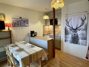 A compact kitchen with a coffee maker, a sink, and a dining area with a table set for four. - Studio cabin Les Saisies, 4 people, central with balcony (Les Saisies)